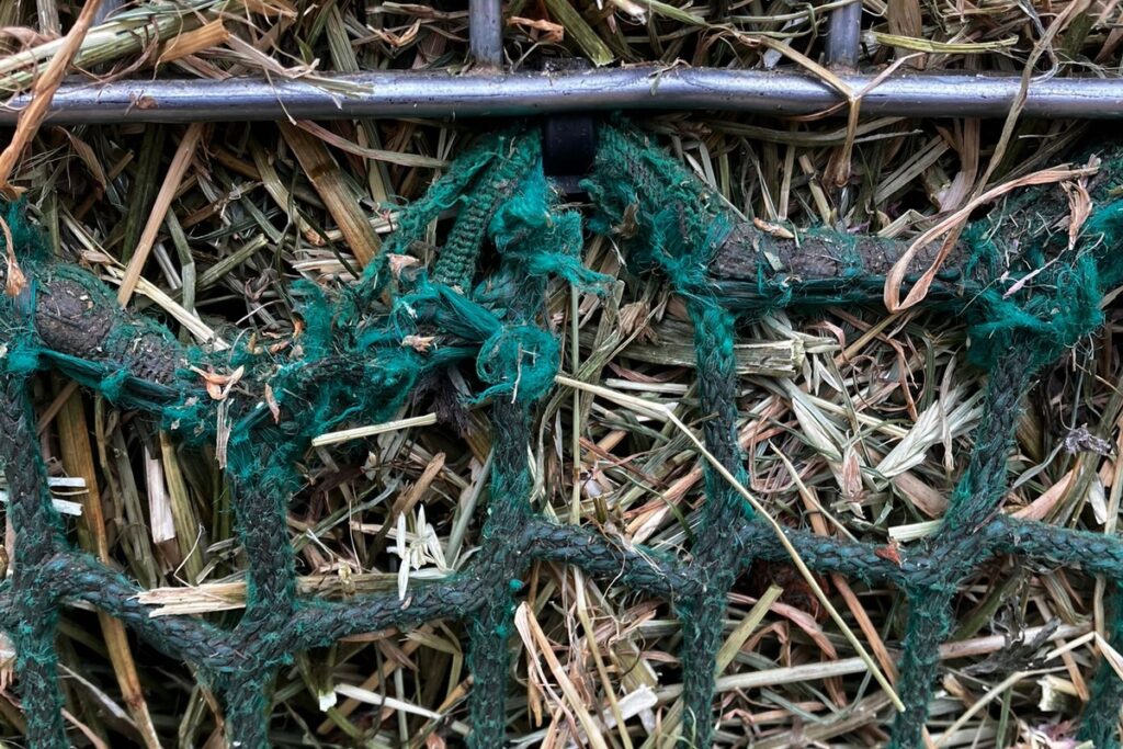 Heunetz beschädigt durch Kabelbinder an der Heuraufe (Scheuerstelle)